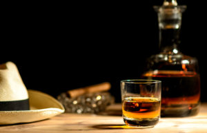 Rum-Glas, Karaffe, Zigarrre und Hut